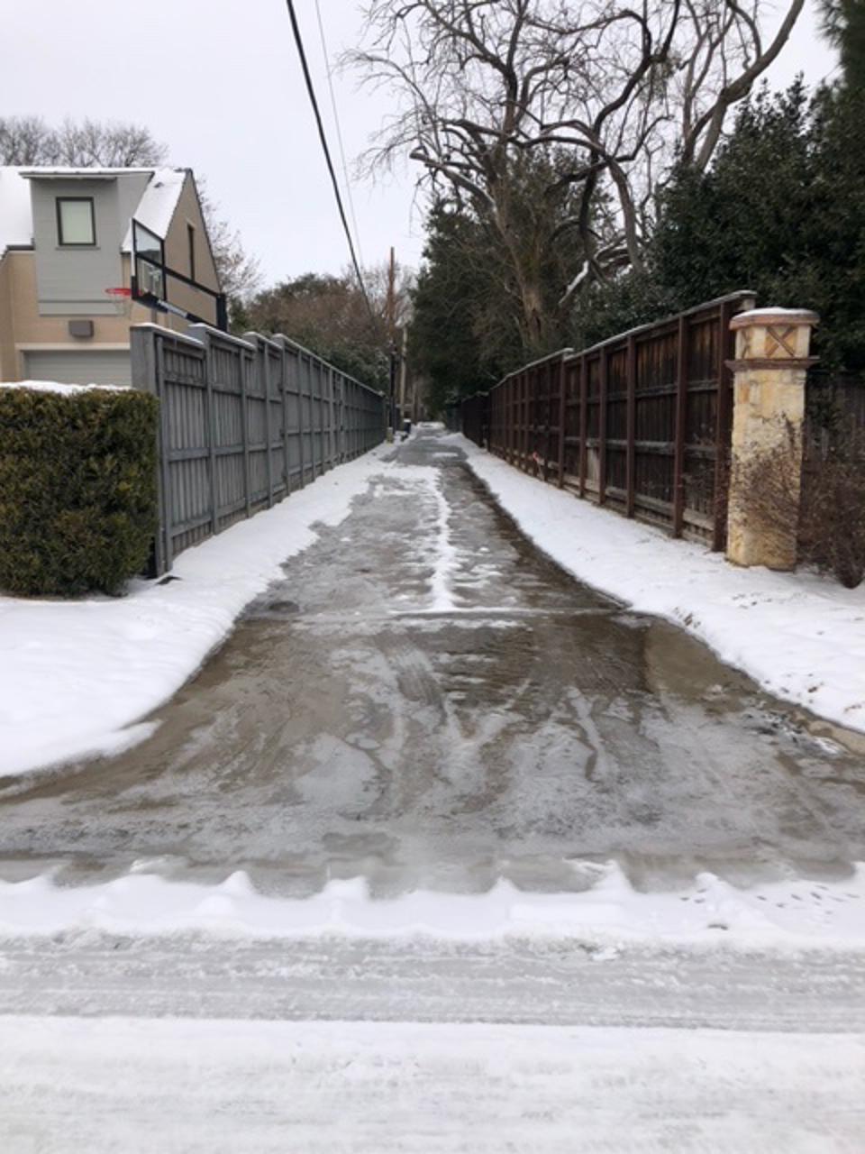 ice from a water pipe burst coats our alley
