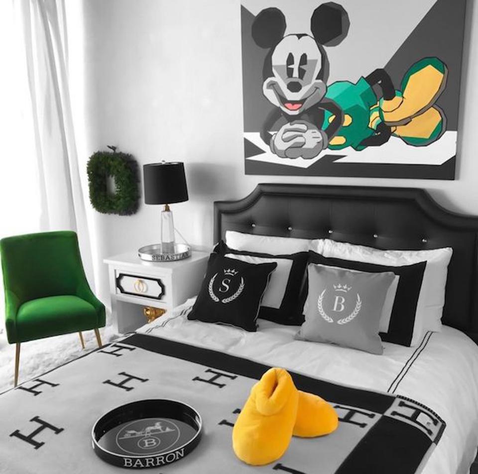 A bedroom with a Mickey Mouse painting by artist Elizabeth Sutton and Hermes bedding.