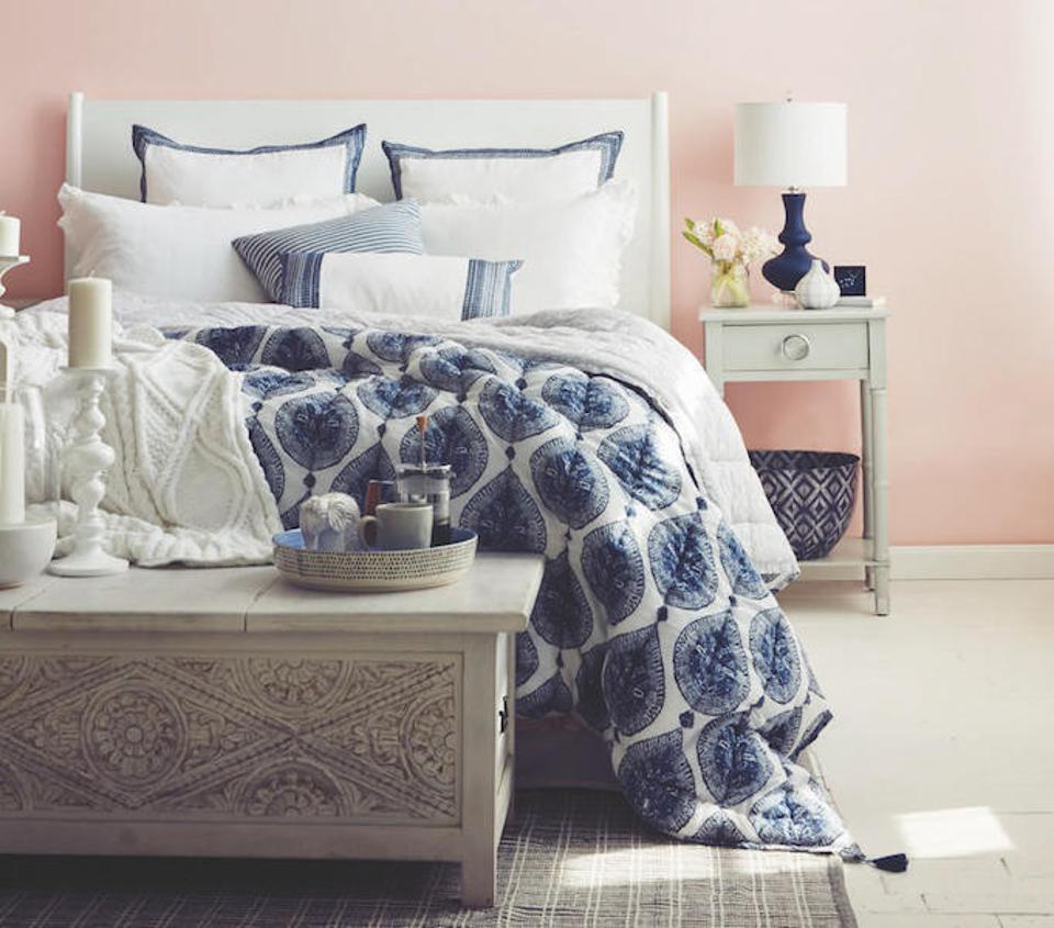 A bedroom without a bedroom set and blue print duvet.